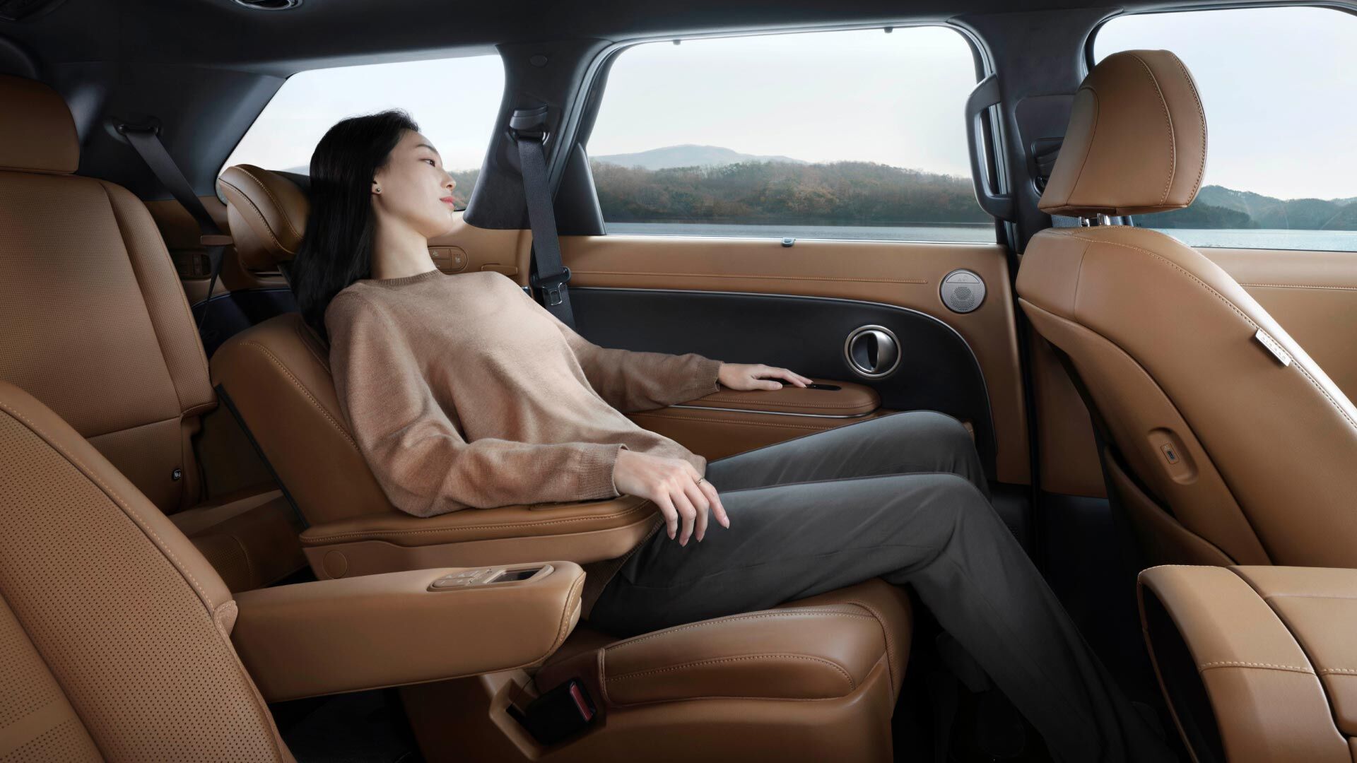 Side-front view of orange Grandi10 with lakeside view at night